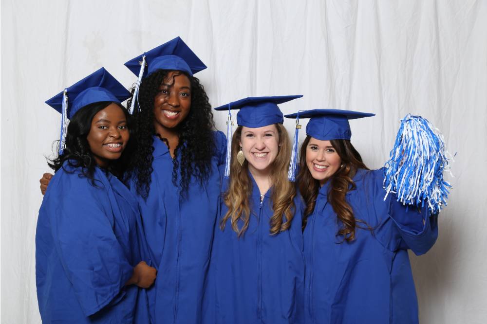 Four graduates pose together at GradFest